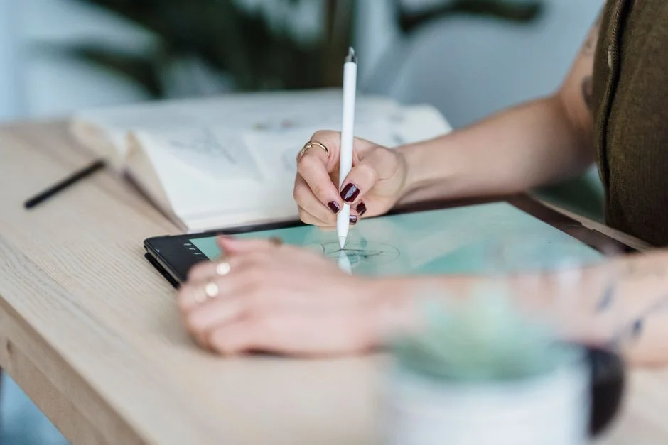 Person zeichnet mit einem Stift auf einem Grafiktablet.