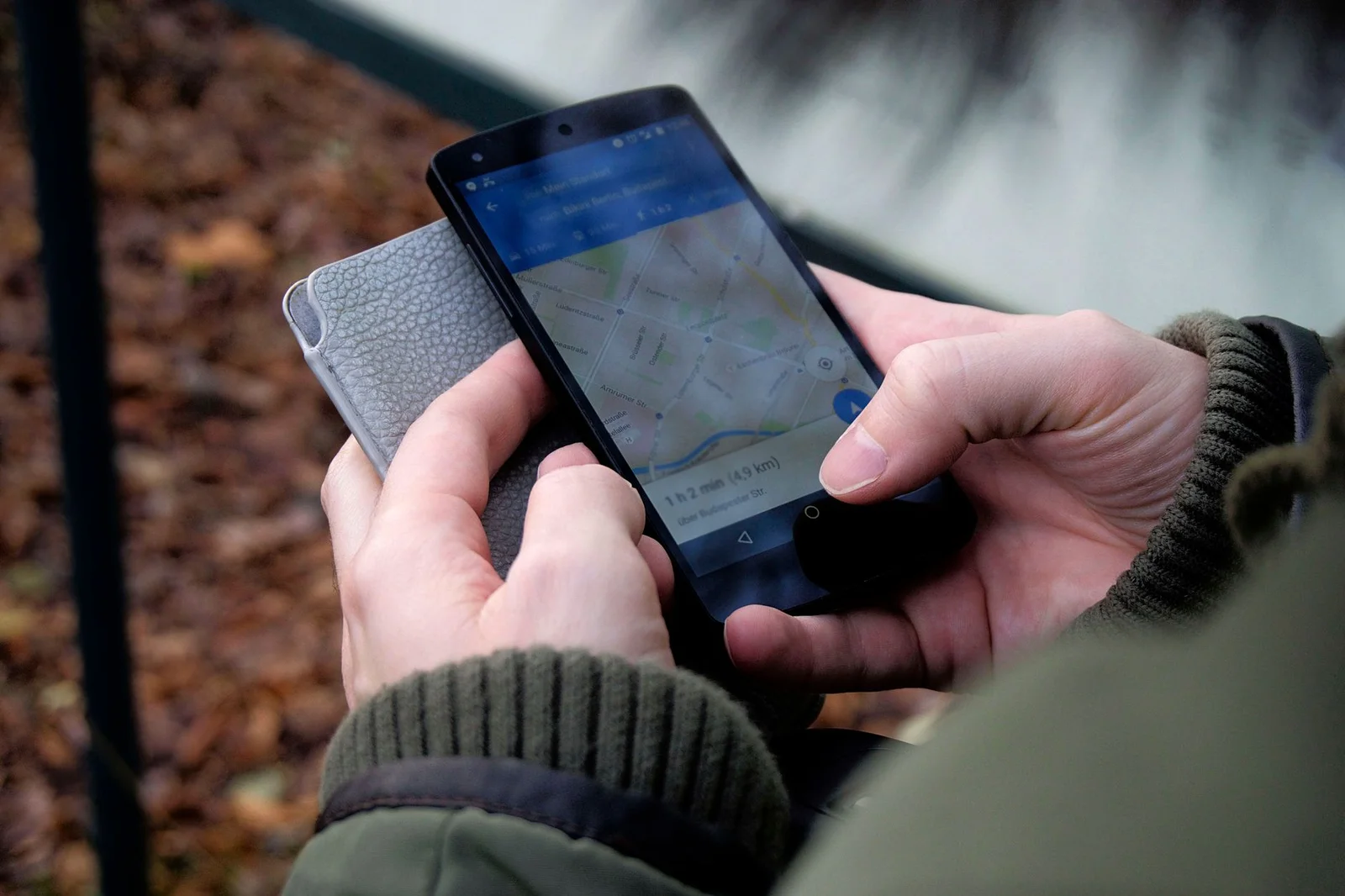Hand hält Smartphone mit geöffneter Google Maps Ansicht zur lokalen Unternehmenssuche