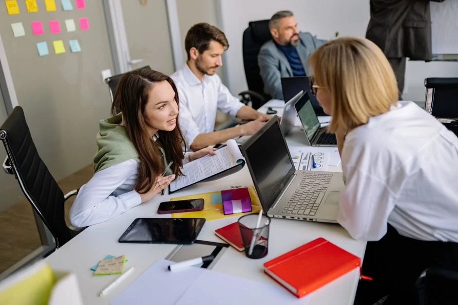 Kleines Team bespricht den Neuaufbau einer Website am Besprechungstisch