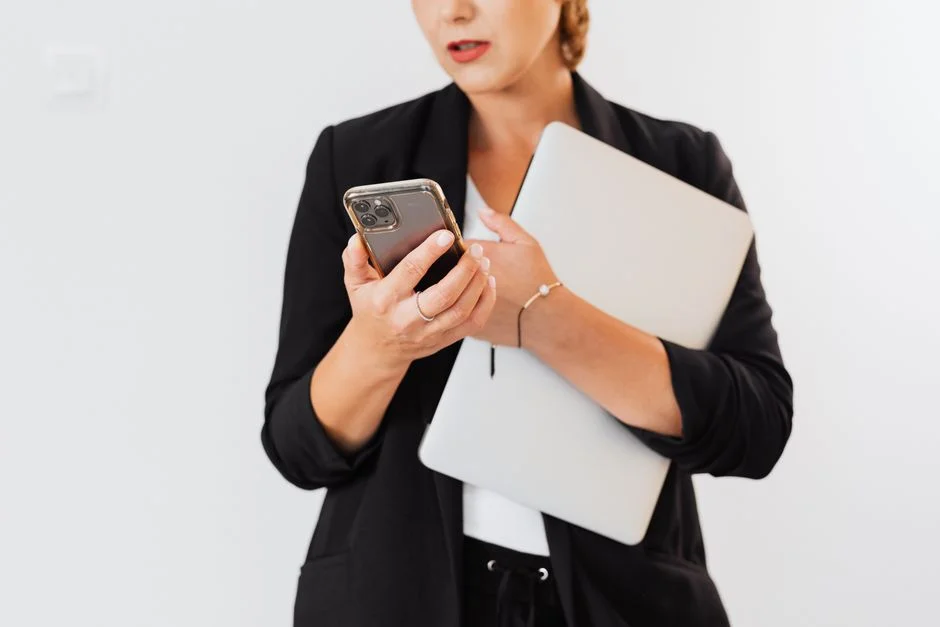 Frau hält ein Smartphone und ein Tablet im Büro.