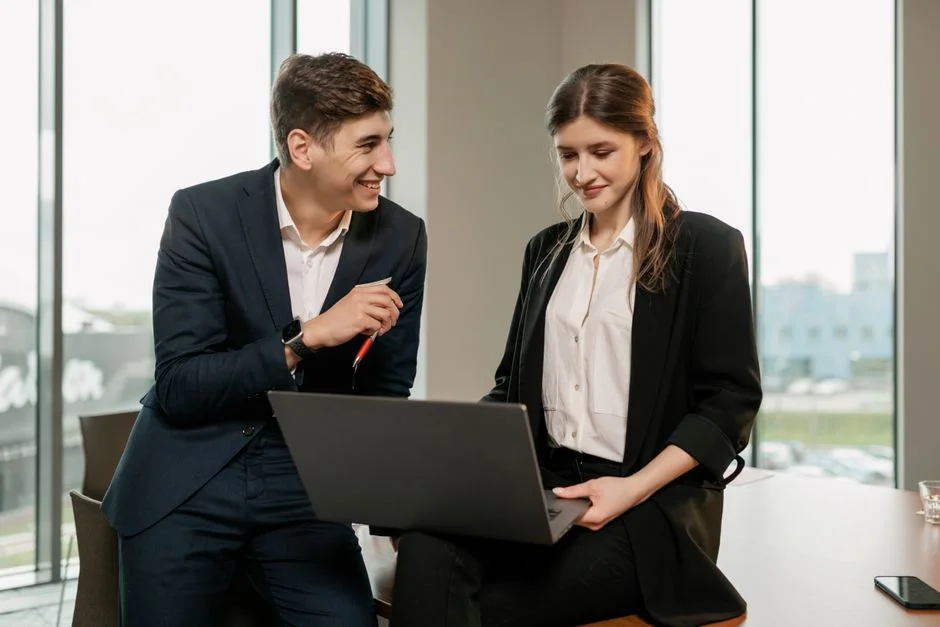 Zwei Personen arbeiten gemeinsam an einem Laptop im Büro