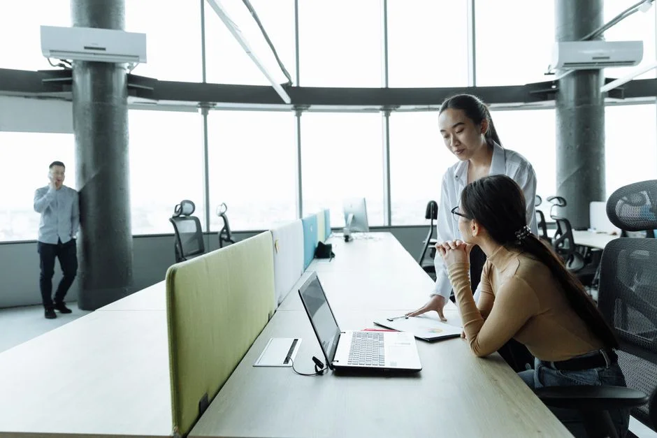 Zwei Frauen besprechen an einem Laptop die nächsten Arbeitsschritte