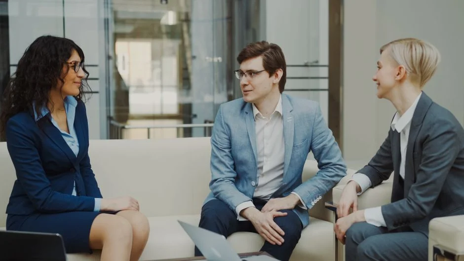 Drei Personen besprechen eine Auswertung in einem modernen Büro