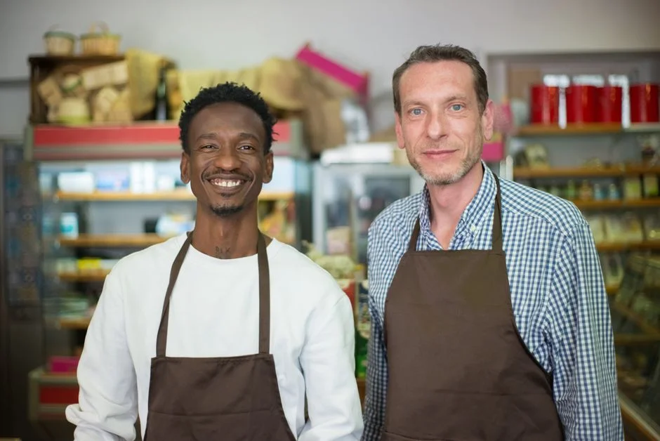 Zwei Bäcker stehen in einem Verkaufsraum mit Regalen