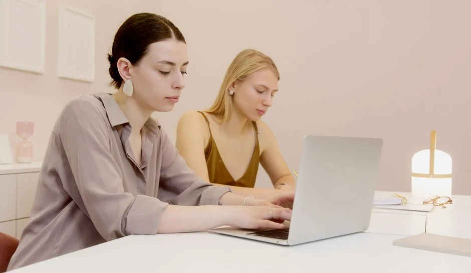 Zwei Frauen arbeiten gemeinsam an einem Laptop