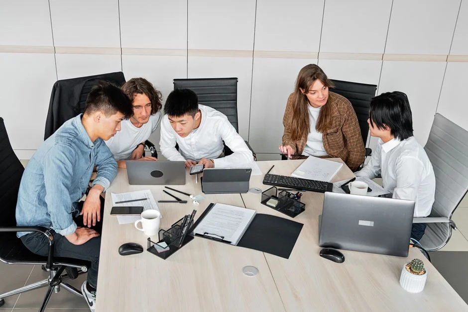 Team bespricht Website-Projekt mit Laptop und Unterlagen im Büro