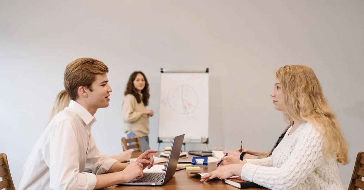 Geschäftspartner besprechen ein Website-Projekt mit Laptop und Flipchart