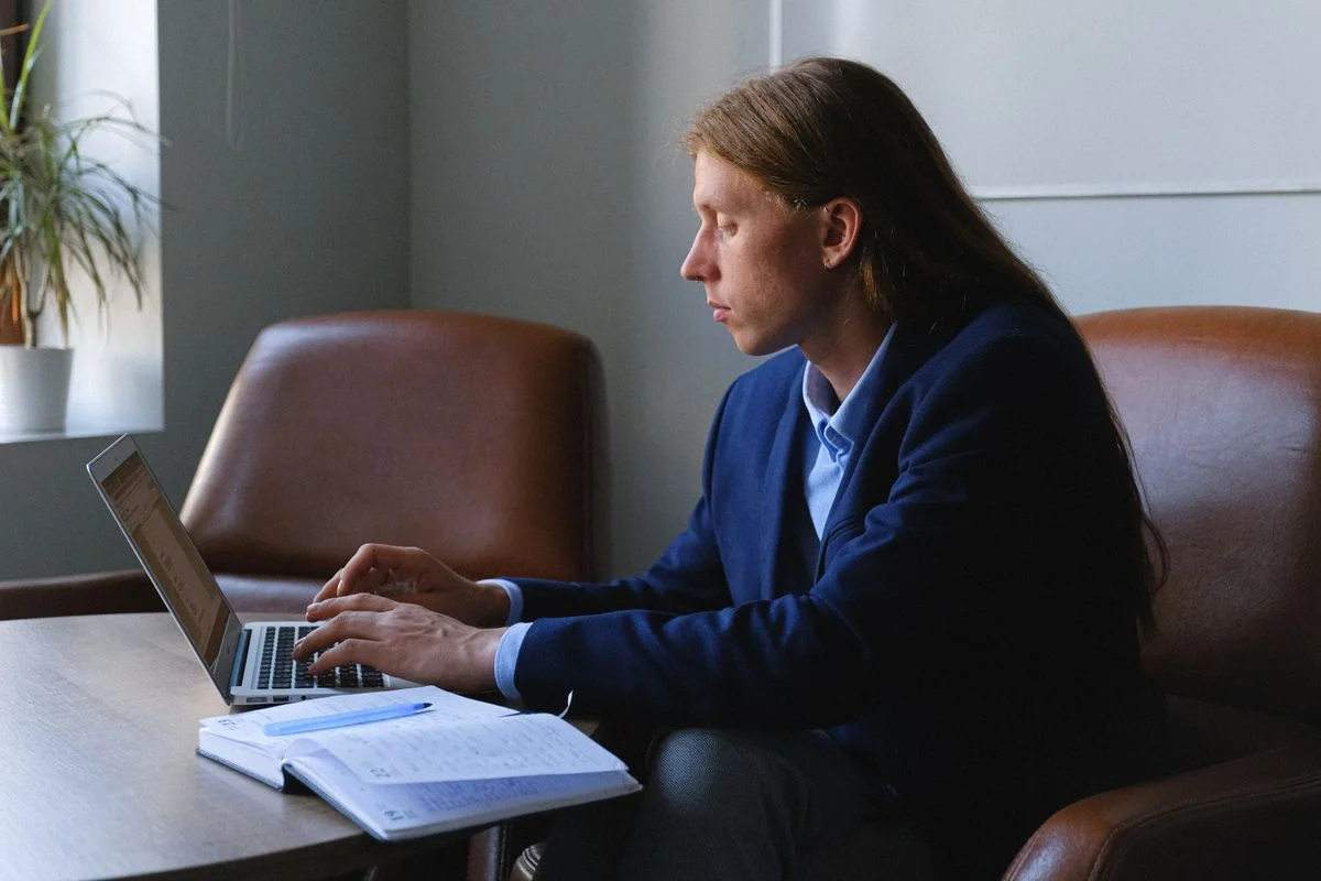 Unternehmerin prüft Backup und technische Aufgaben am Laptop